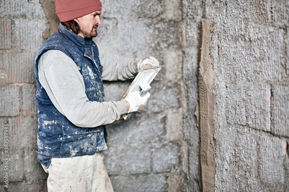 Real construction worker working on a wall inside the new house. Real construction worker working on a wall inside the new house.