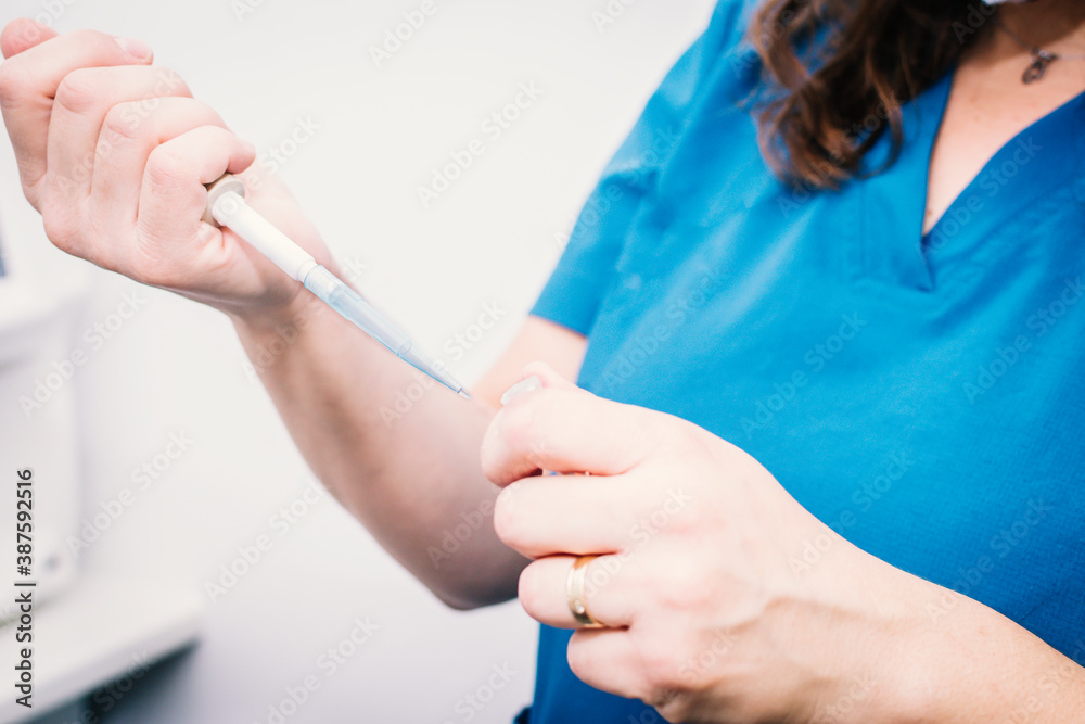 Close-up of a nurse taking samples with a canister Close-up of a nurse taking samples with a canister