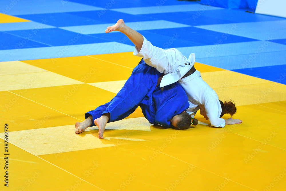 Two Girls judoka in kimono compete on the tatami Two Girls judoka in kimono compete on the tatami