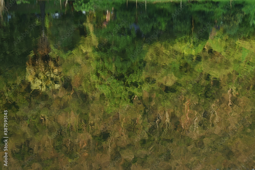 blurry reflection of tree on water suface Khao Ruak reservoir camping point for traveler at Sam Lan waterfall in Thailand blurry reflection of tree on water suface Khao Ruak reservoir camping point for traveler at Sam Lan waterfall in Thailand