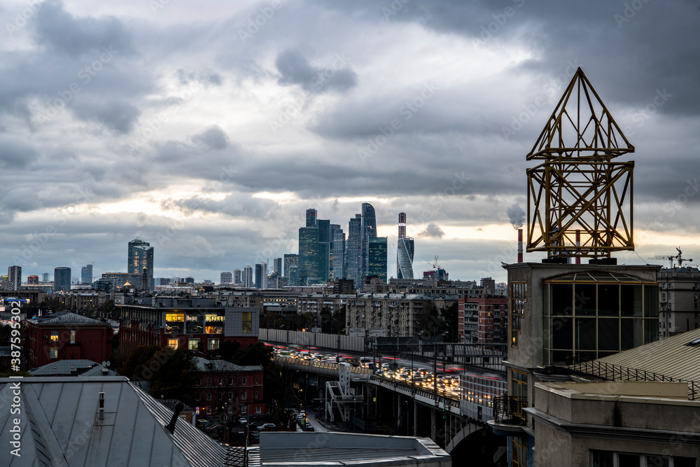 Fototapeta premium cityscape with modern buildings and highways against the backdrop of the river and the setting sun