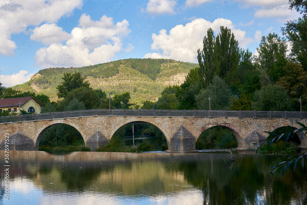 Beautiful old bridge over a calm river on a Sunny day