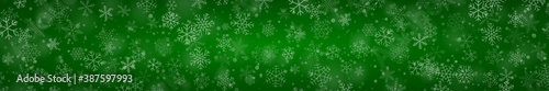 Christmas banner of snowflakes of different shapes, sizes and transparency on green background