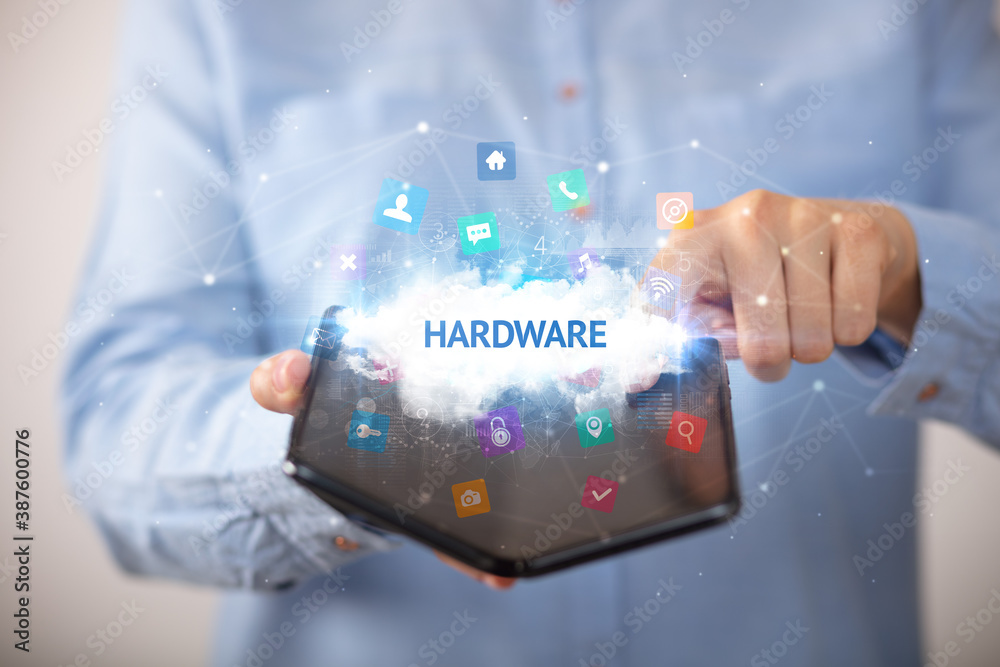 Businessman holding a foldable smartphone with HARDWARE inscription, technology concept Businessman holding a foldable smartphone with HARDWARE inscription, technology concept