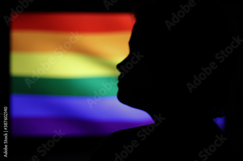 silhouette of a person with a LGTB flag on the background photo