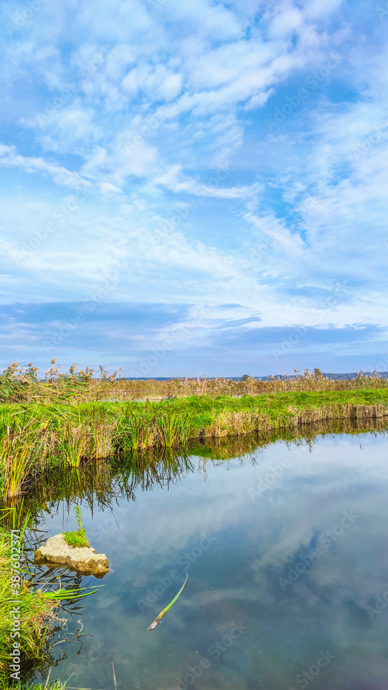 Sunny day on the perfect lake. Autumn lake with reflection on the water. Cloudy sky in the sunny day.