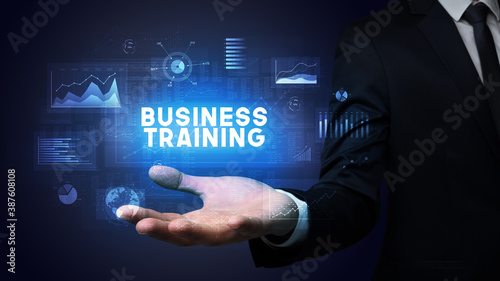 Hand of Businessman holding BUSINESS TRAINING inscription, business success concept