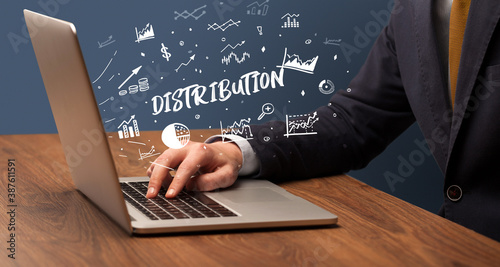 Businessman working on laptop with DISTRIBUTION inscription, modern business concept