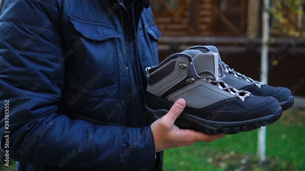 Unrecognizable man carries boots in his hands Unrecognizable man carries boots in his hands