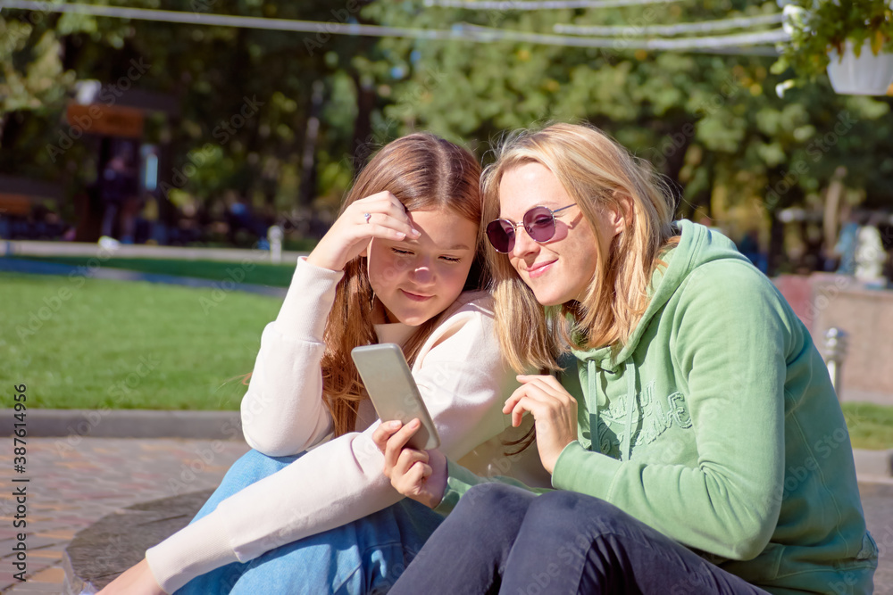 Two pretty girls, hipster girls, sisters using smartphone, close-up. Lifestyle and friendship concept Two pretty girls, hipster girls, sisters using smartphone, close-up. Lifestyle and friendship concept