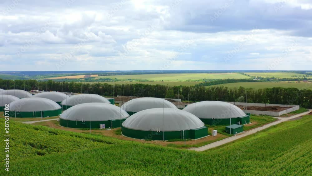 Large reservoirs for biomass. Biogas plant among ecological environment. Industrial plant for renewable energy surrounded by nature. Large reservoirs for biomass. Biogas plant among ecological environment. Industrial plant for renewable energy surrounded by nature.