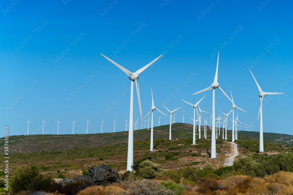 Aerial view large group of eco system wind turbines power generation station on green field in rural landscape in countryside Aerial view large group of eco system wind turbines power generation station on green field in rural landscape in countryside