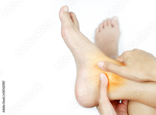 фотографія A young woman massaging her painful ankle.