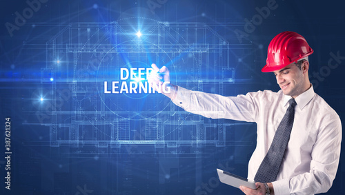 Handsome architect with helmet drawing DEEP LEARNING inscription, new technology concept