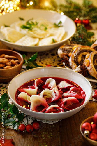 Traditional Christmas beetroot soup borsch with dumplings stuffed with mushrooms close up view