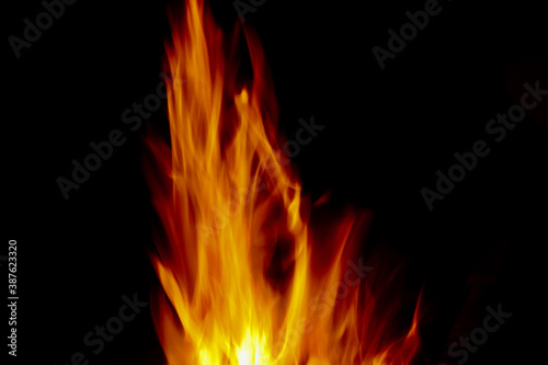 Bright golden orange flames against black background with copy space