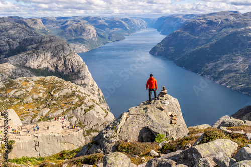 Hiker looking over Preikestolen (Pulpit Rock) above Lysefjord near Stavanger, Norway