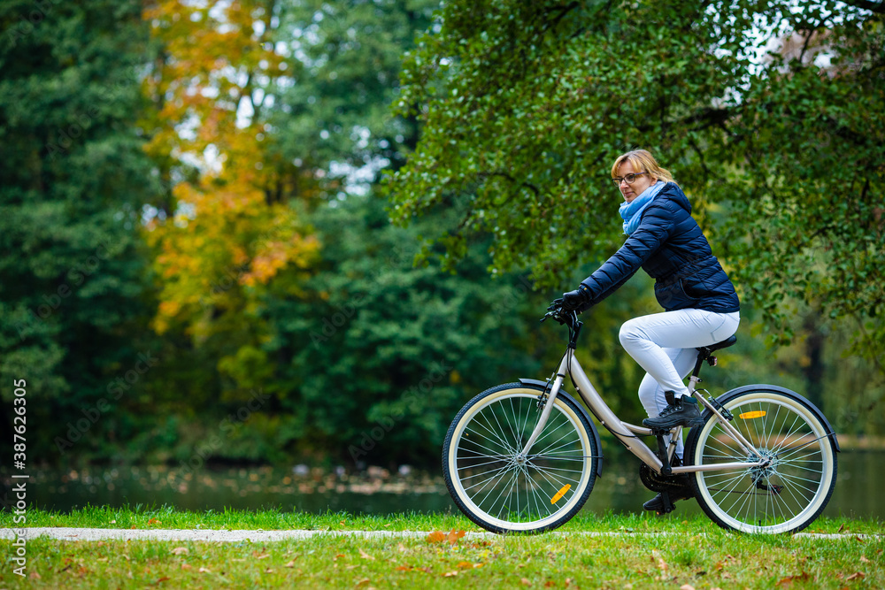 Urban biking - woman riding bicycle in city park
Urban biking - woman riding bicycle in city park