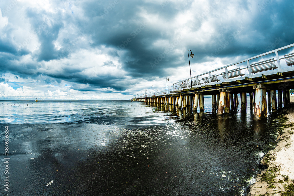 Obraz premium Gulf and pier under cloudy sky