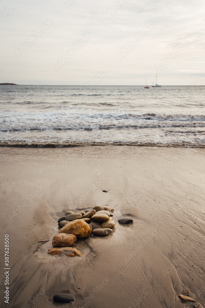 des pierres et des cailloux sur une plage de sable fin avec les vagues de la mer. des pierres et des cailloux sur une plage de sable fin avec les vagues de la mer.