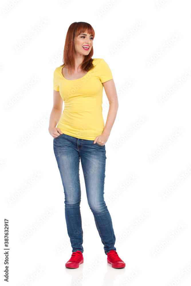 Happy Casual Young Woman Is Standing With Hands In Pockets, Looking Away And Talking Happy Casual Young Woman Is Standing With Hands In Pockets, Looking Away And Talking