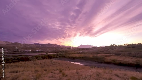 Colorful cloudscape over a mountain landscape - town nestled in an idyllic valley time lapse photo