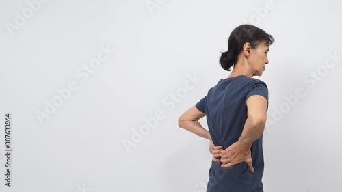 Asian senior or older woman had a back pain posture on white background. © nisara