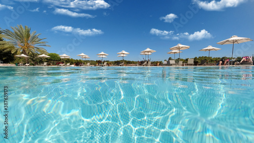 Photo Underwater split photo of paradise turquoise pool as seen in exotic resort