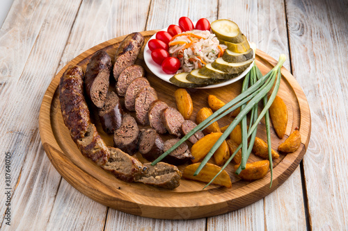 Beef sausage appetizer with potatoes and pickles