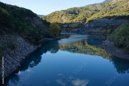 reflection of colorful trees in the fall in lake Serre Ponçon, France