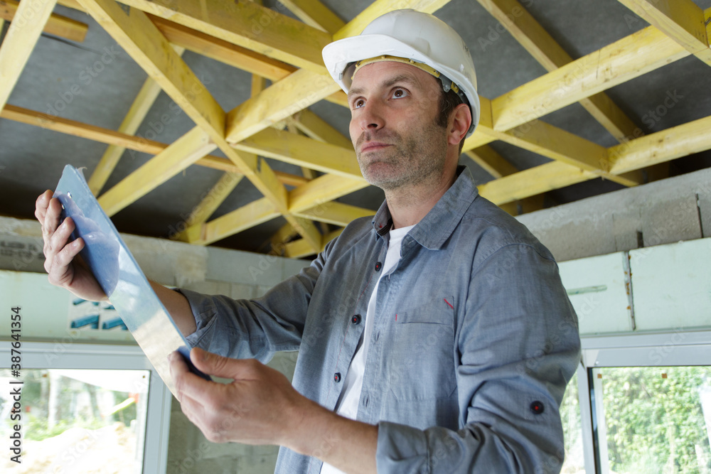 man builder stands with clipboard indoors man builder stands with clipboard indoors