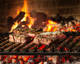 Vista de frente de 4 pedazos de carne, asado al carbon y leña, parrilla de metal y colores calientes