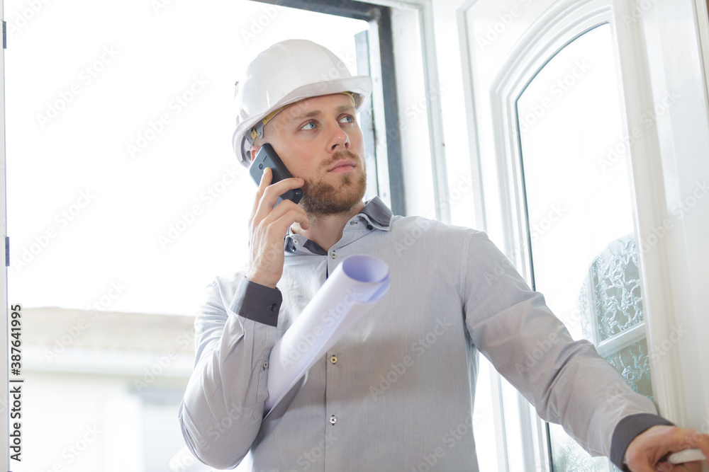 successful male architect in helmet talking mobile phone successful male architect in helmet talking mobile phone
