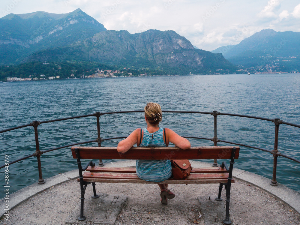 Woman sitting on a bench in front Como Lake