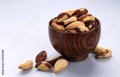 Brazil nuts in wooden bowl on white background