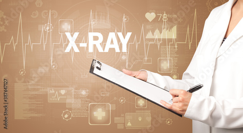 young doctor writing down notes with X-RAY inscription, healthcare concept