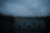 Rain drops on window glass surface with city background . Natural Pattern of raindrops on glass
