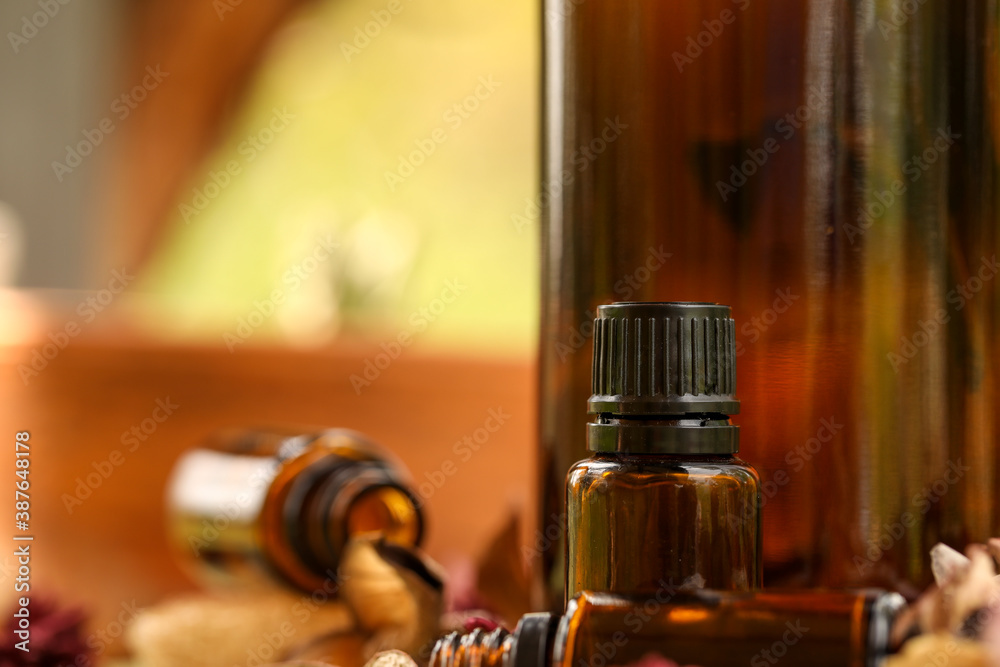 Selection of various sized amber bottles on wooden surface with dried flowers and leaves. Rustic wellness image. Selection of various sized amber bottles on wooden surface with dried flowers and leaves. Rustic wellness image.