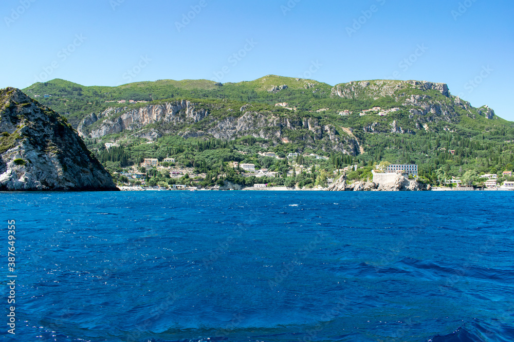 The green hills towering over Palaiokastritsa resort in Corfu, Greece, as seen from a boat