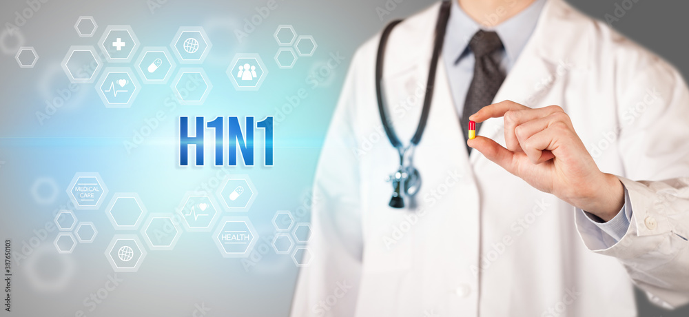 Close-up of a doctor giving you a pill with H1N1 inscription, medical concept Close-up of a doctor giving you a pill with H1N1 inscription, medical concept