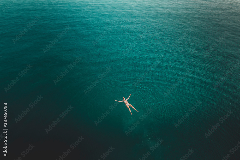 Young caucasian woman swimming in a wide open sea in mediterranean sea in Croatia on a sunny summer day