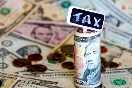 Tax signage with a background of American dollars.