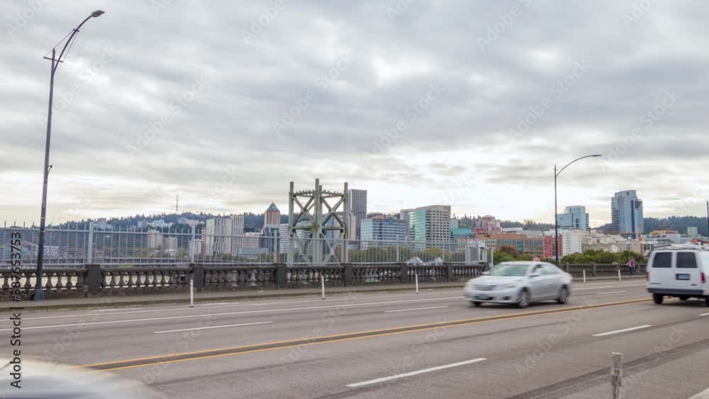Portland Oregon cityscape skyline hyperlapse as seen from the Burnside Bridge which spans over the Willamette River with cars driving to and from the downtown city center. Portland Oregon cityscape skyline hyperlapse as seen from the Burnside Bridge which spans over the Willamette River with cars driving to and from the downtown city center.