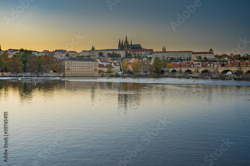 beautiful view of the sights of Prague Castle and St. Vitus Cathedral and Charles Bridge and the level of the Vltava River in the center of Prague at sunset. the sun colors the sky orange