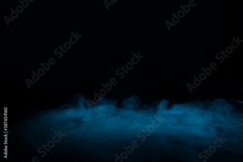 Abstract blue smoke moves on black background. Mystical swirling smoke rolling low across the ground. © KDdesignphoto