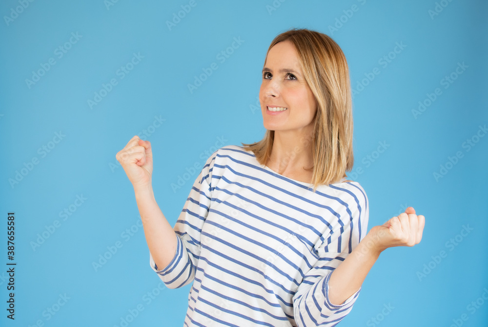 Image of excited young lady standing isolated over blue background make winner gesture. Image of excited young lady standing isolated over blue background make winner gesture.
