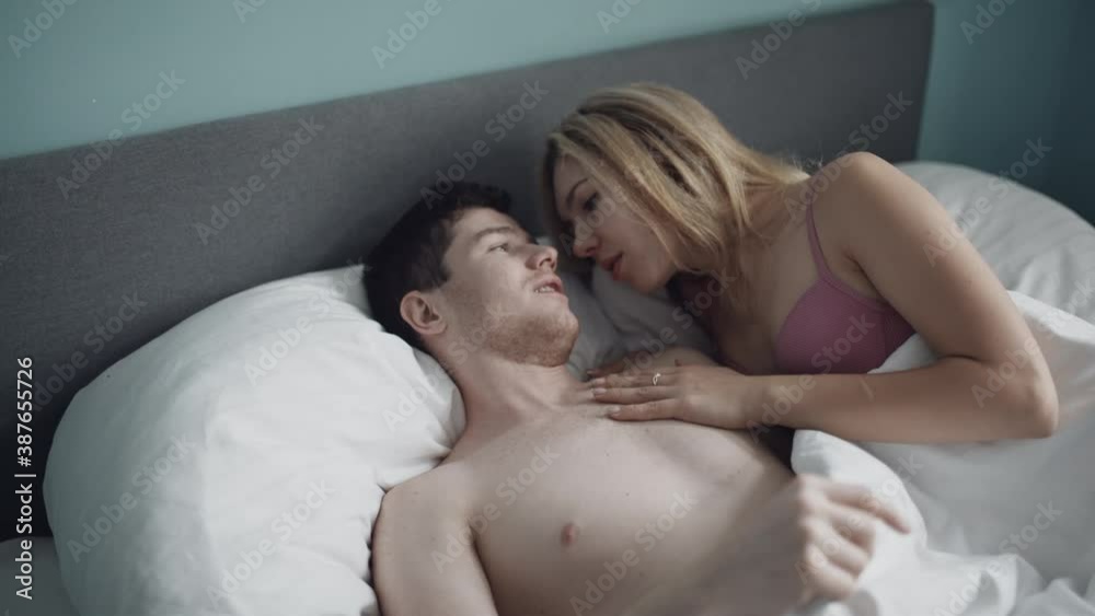 Sexy couple making love in bedroom. Handsome man kissing woman in bra. Attractive couple having foreplay in bed. Sensual couple enjoying romantic time together at hotel. Erotic or intimacy concept. Sexy couple making love in bedroom. Handsome man kissing woman in bra. Attractive couple having foreplay in bed. Sensual couple enjoying romantic time together at hotel. Erotic or intimacy concept.