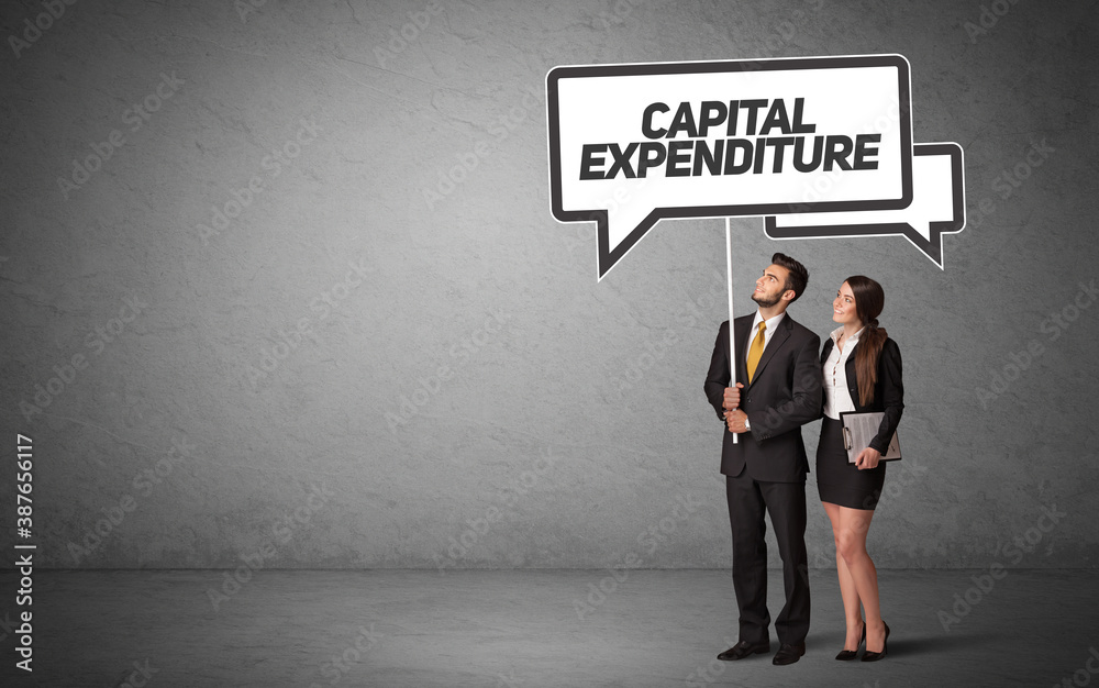 Young business person in casual holding road sign with CAPITAL EXPENDITURE inscription, new business idea concept Young business person in casual holding road sign with CAPITAL EXPENDITURE inscription, new business idea concept