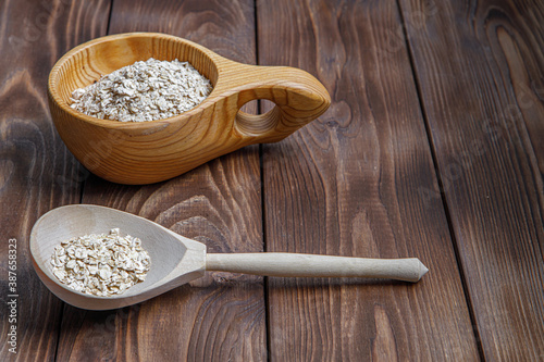 Wooden Cup and spoon with oatmeal. Health food. Wood texture