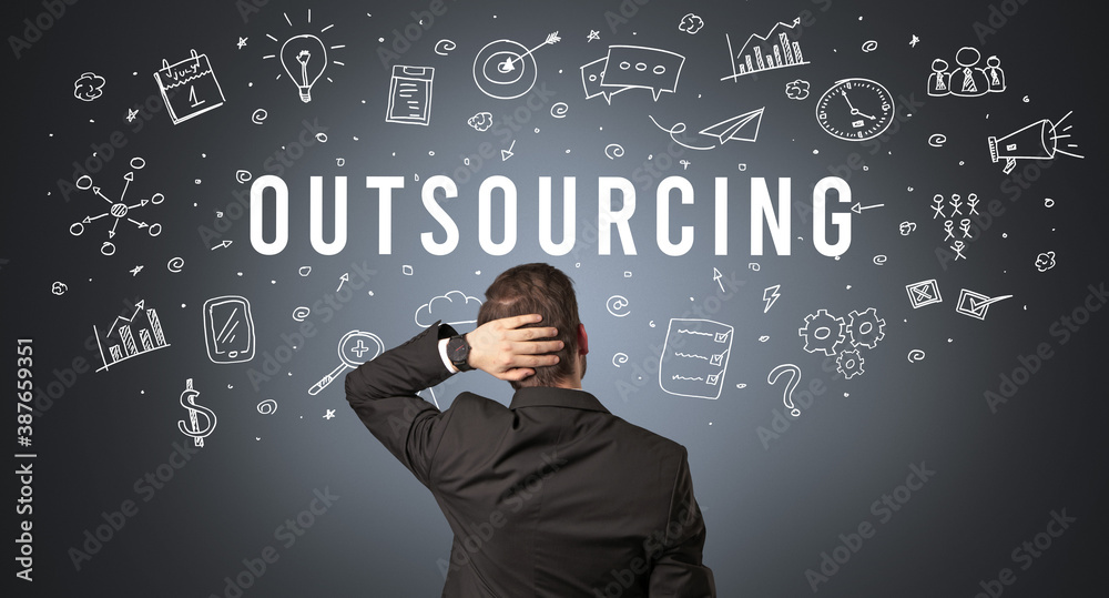 Rear view of a businessman with OUTSOURCING inscription, modern business concept Rear view of a businessman with OUTSOURCING inscription, modern business concept
